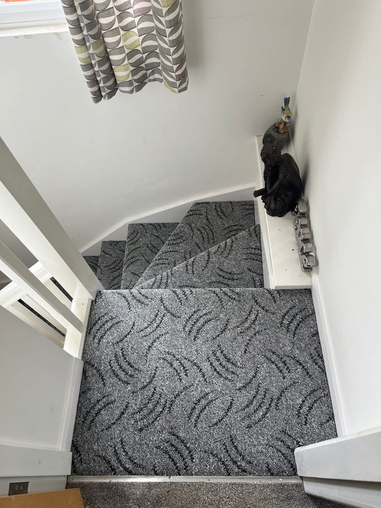 Grey carpet fitted around a winder staircase turn